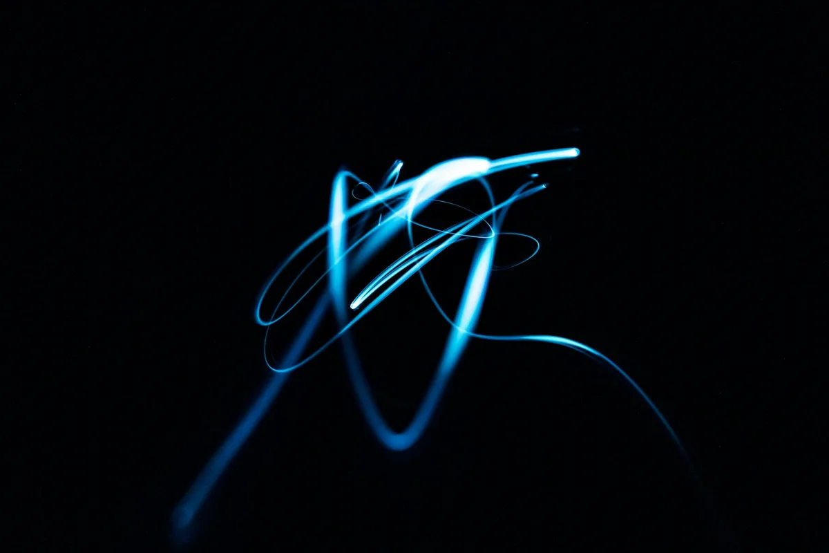 Blue and black abstract light streaks against a dark background
