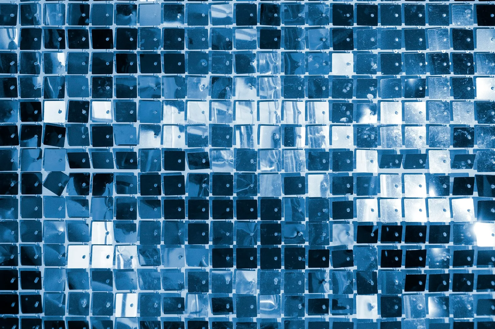 Close-up of a blue mosaic tile wall showing a repeating grid pattern