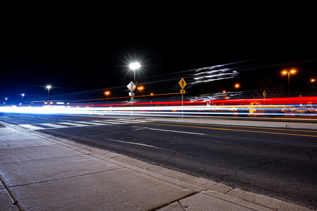 Colorful light trails streaking along a city street at night from a long exposure
