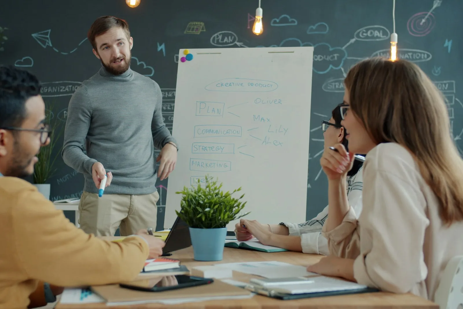 A cross-functional team collaborating around a whiteboard during a design system planning meeting