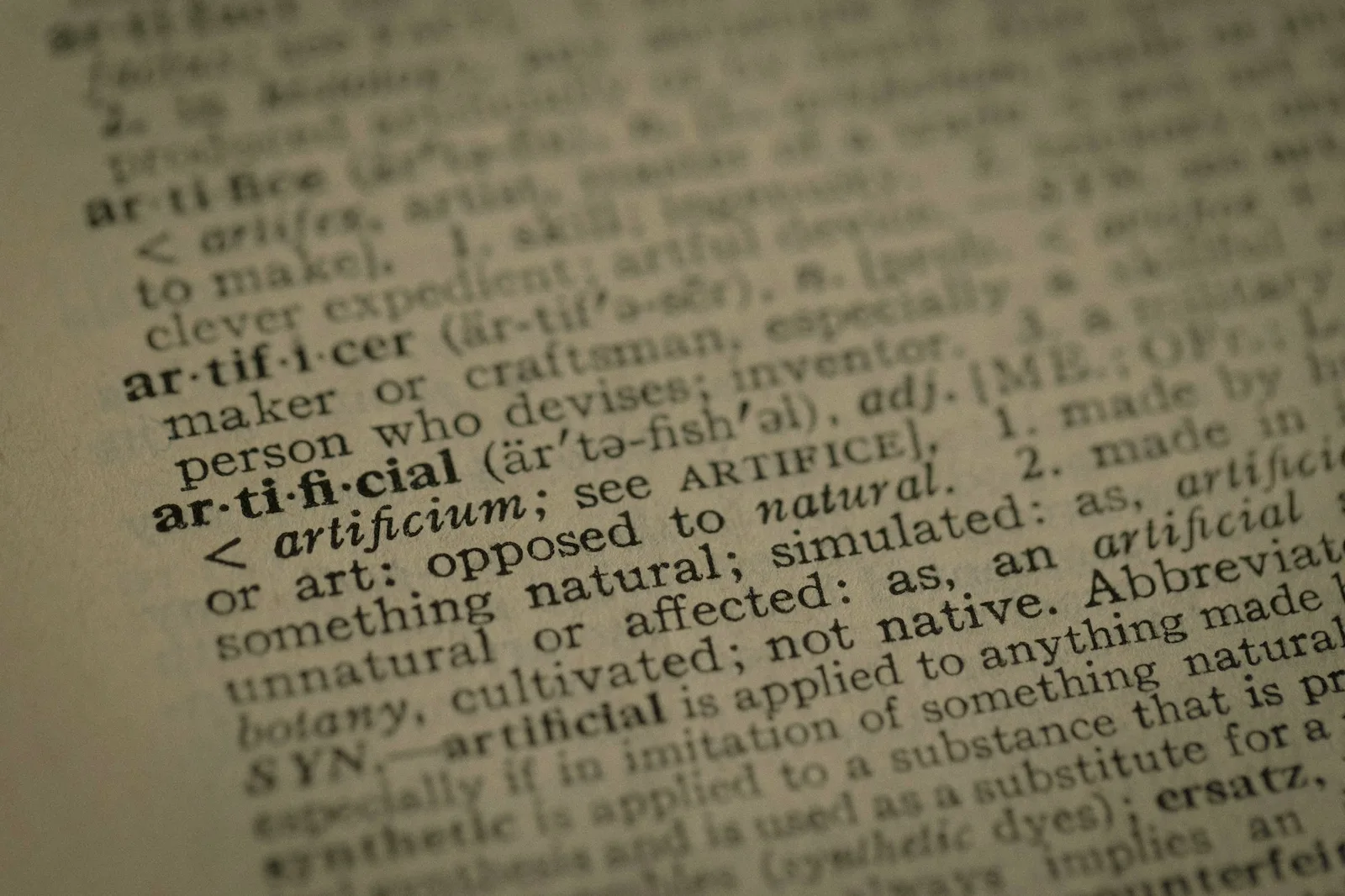 Close-up of dictionary text pages showing dense typeset paragraphs