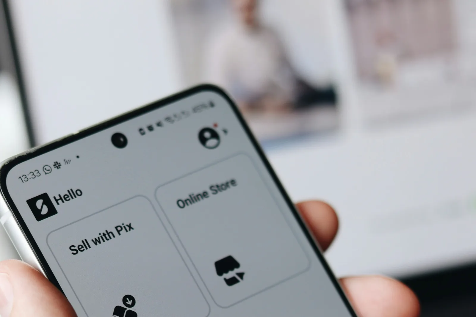 Close-up of a hand holding a smartphone displaying an app interface