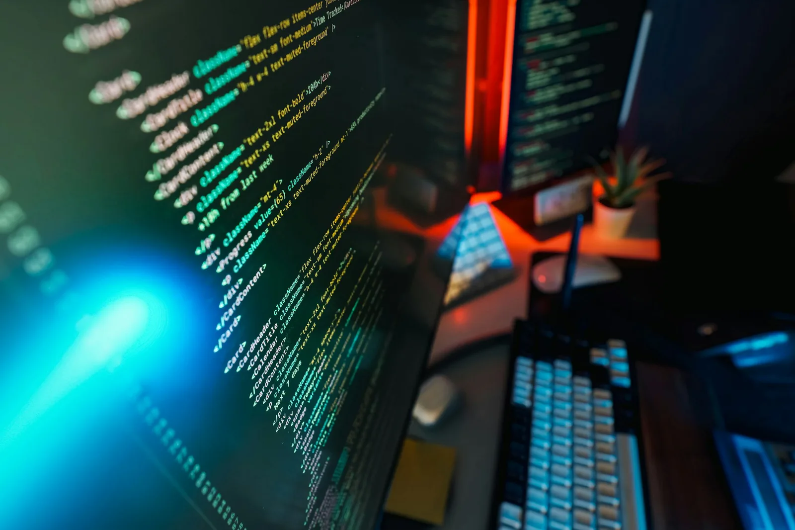 Multiple computer screens displaying component code in a modern development workspace