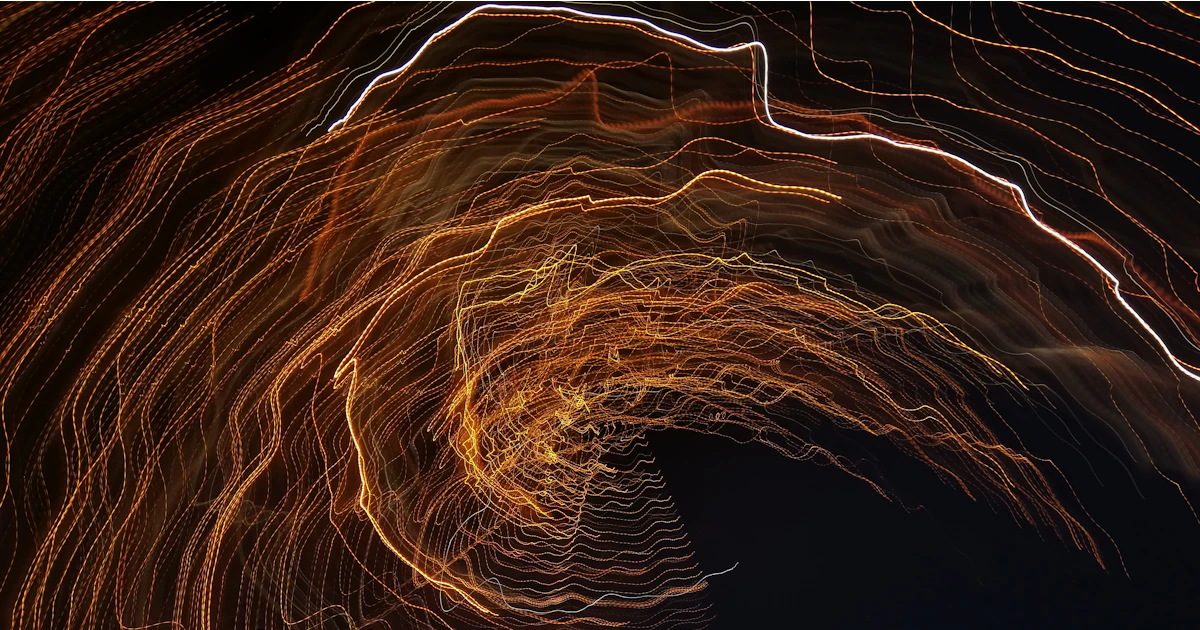 Long-exposure light trails of fire against darkness