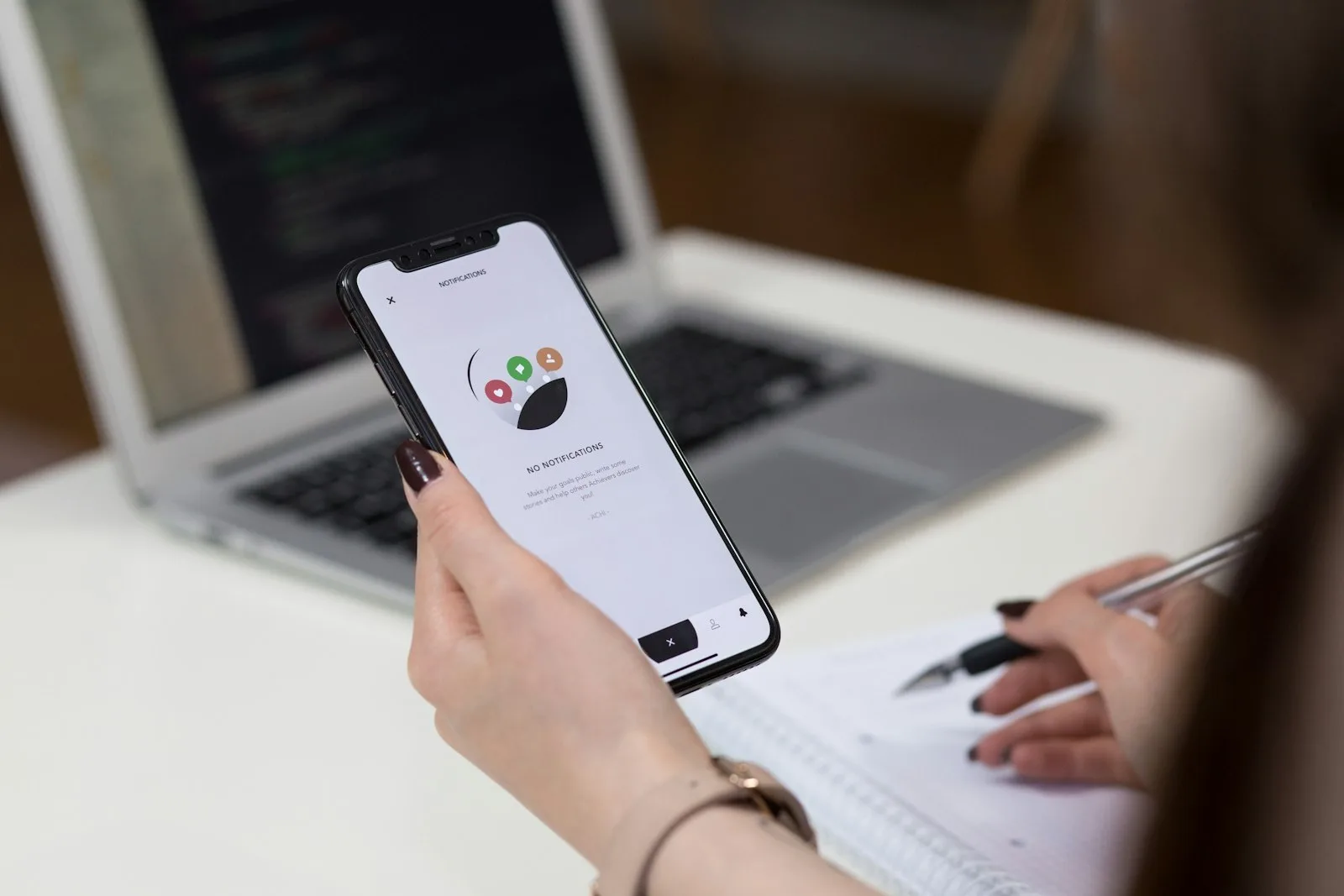 A person using a smartphone app beside notes during a low-budget mobile usability test