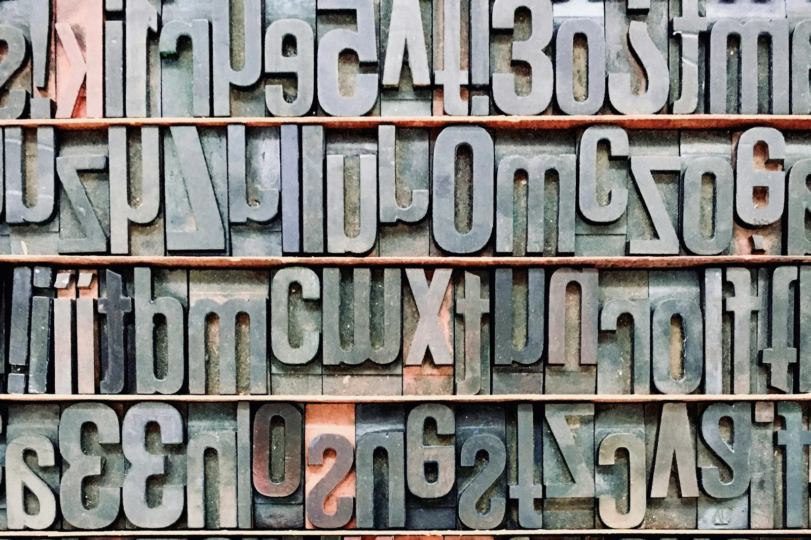 Black alphabet letters mounted on a wall showing varied typeface weights and forms