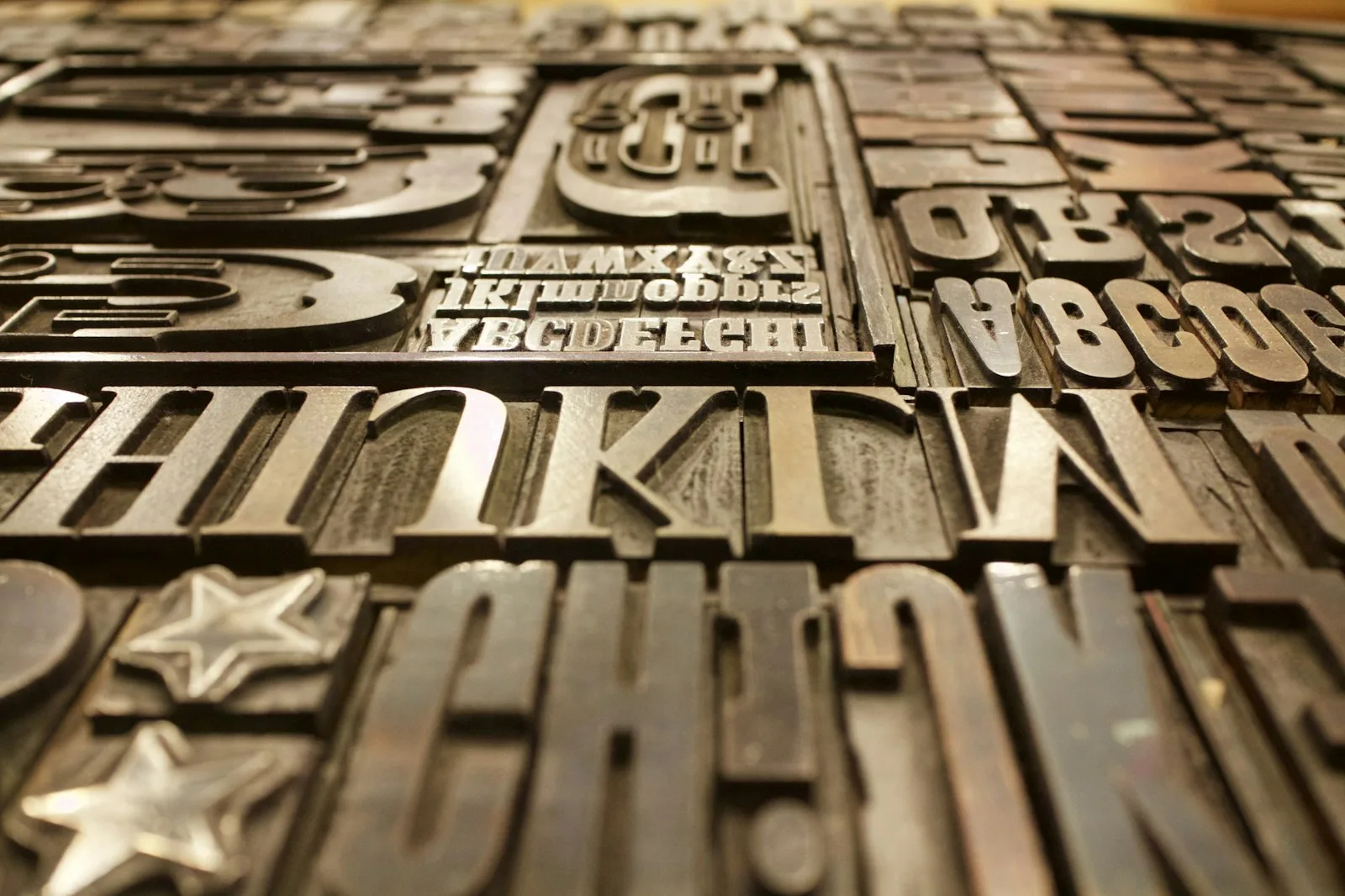 Close-up of assorted metal letterpress type blocks showing varied typography and letterforms