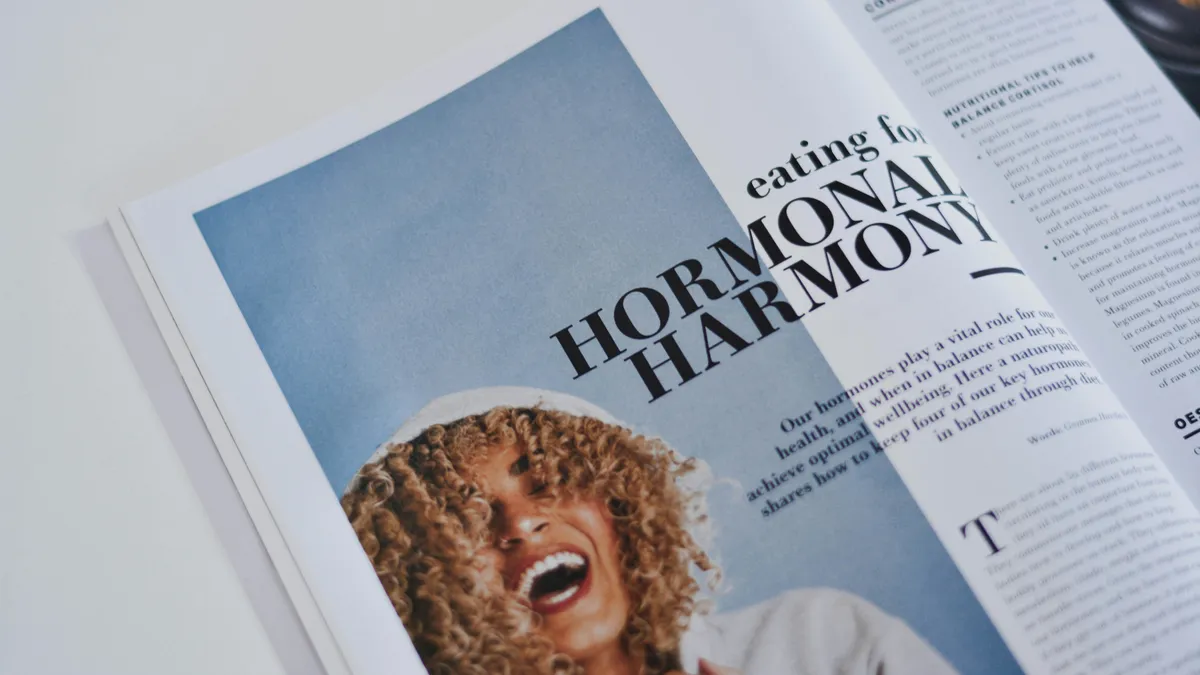 Open magazine spread with a large headline over a photograph and a narrow side column of small text on the right page