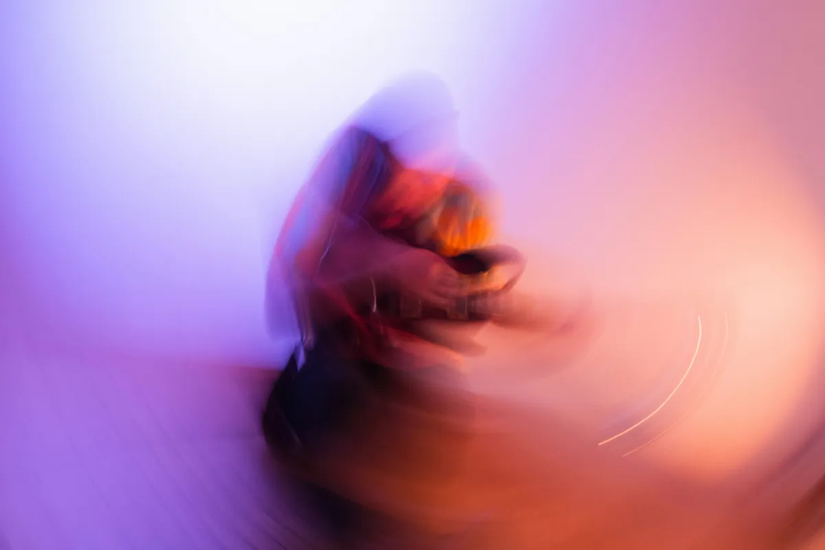 A phone screen smeared into a purple streak by a long exposure