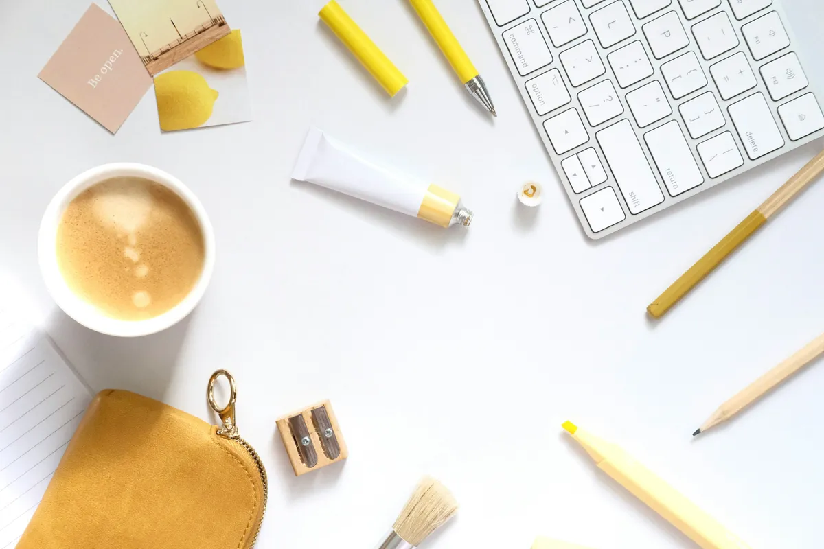 A flat lay of coffee and art supplies arranged on a desk
