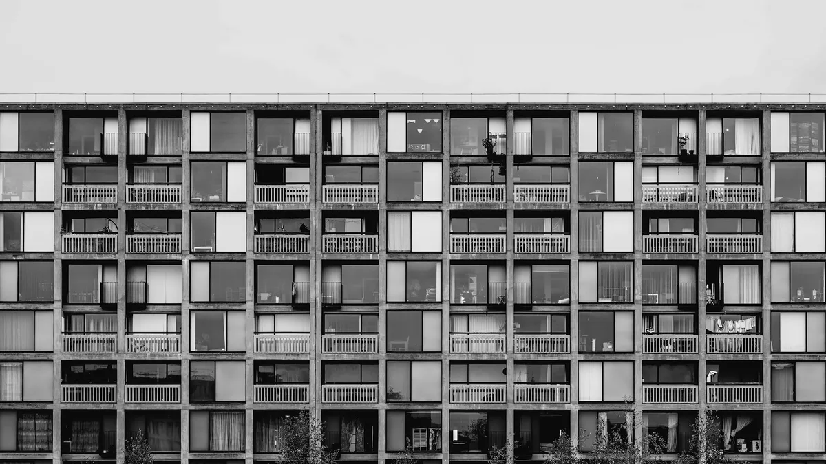 Grid of uniform windows on a brutalist apartment building facade