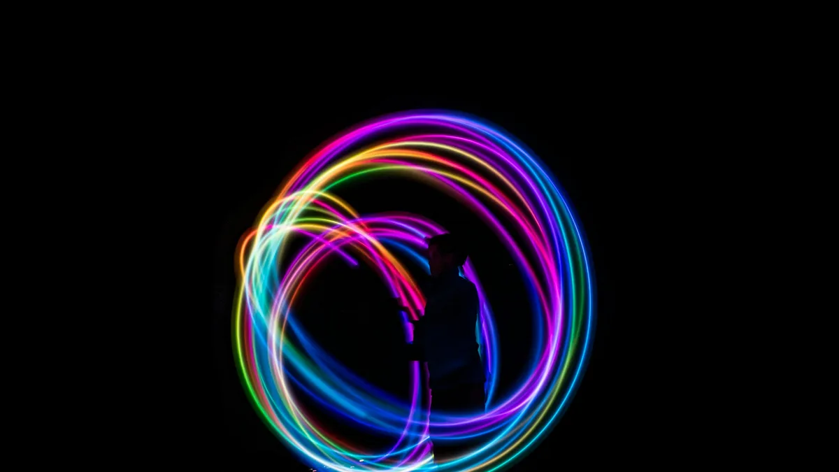 Long-exposure light trails curving across a deep blue background like eased motion paths