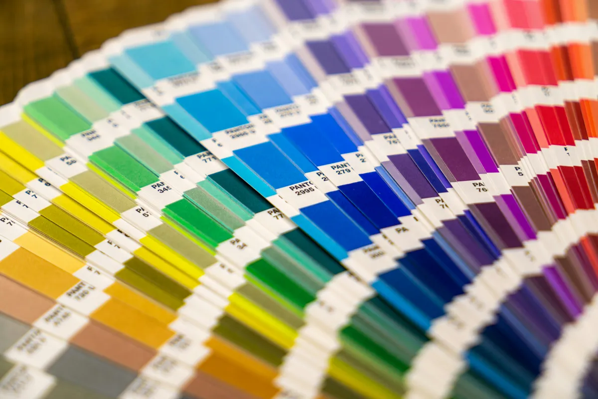 A color fan deck opened out into a full spectrum of paper swatches