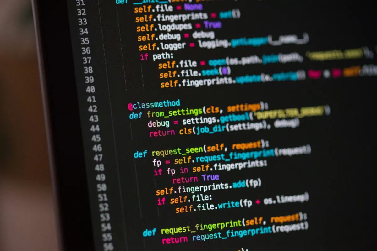 Colorful syntax-highlighted code on a dark monitor, illustrating how saturated colors read against dark backgrounds