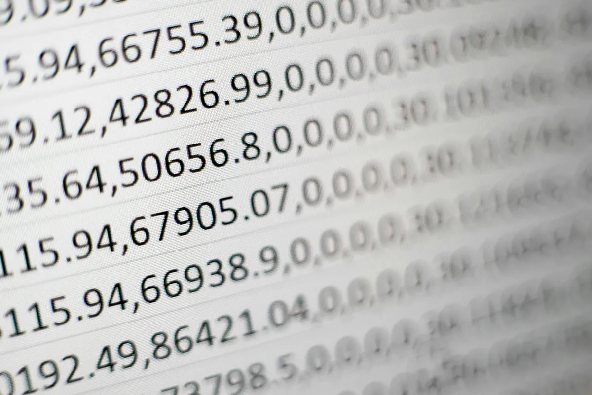 Extreme close-up of dense numerical data on a printed report, illustrating the limits of raw information density