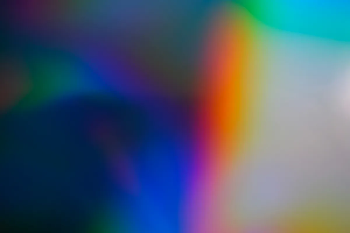 A grainy gradient running from deep blue into orange and teal