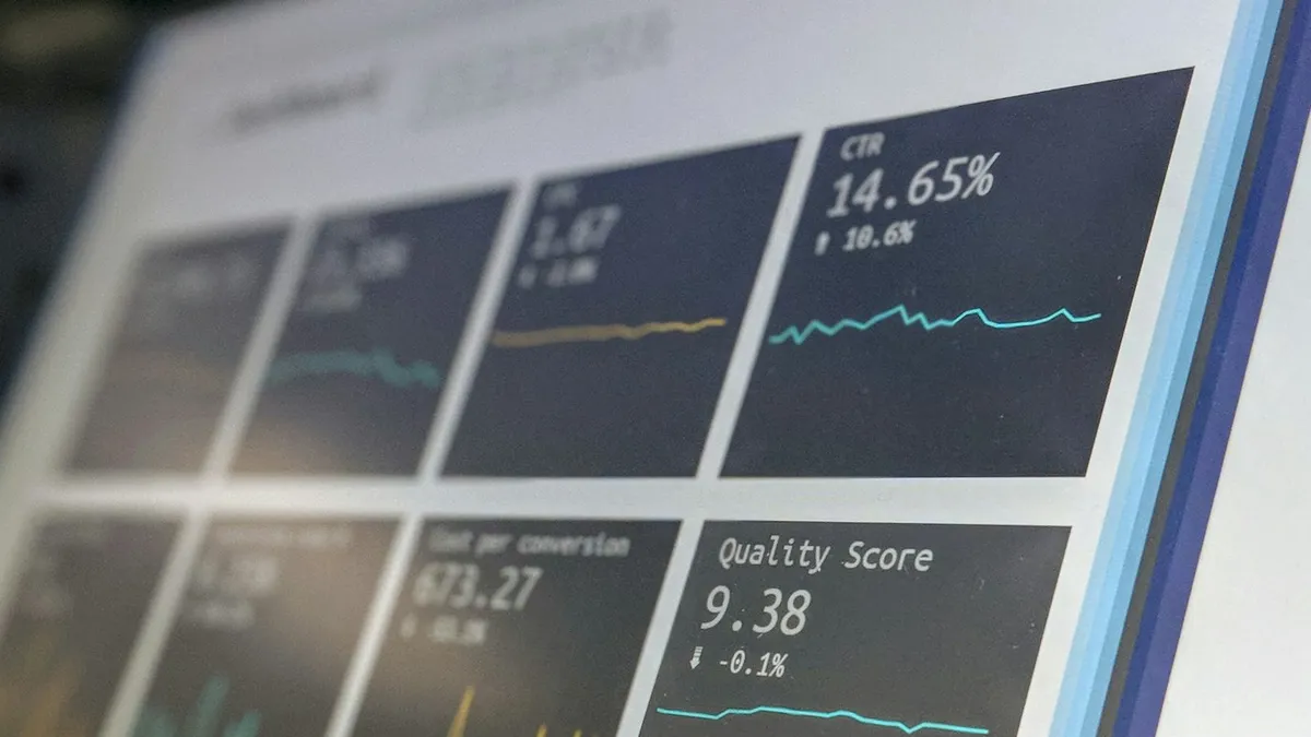 Monitor displaying a data reporting dashboard with KPI cards and charts