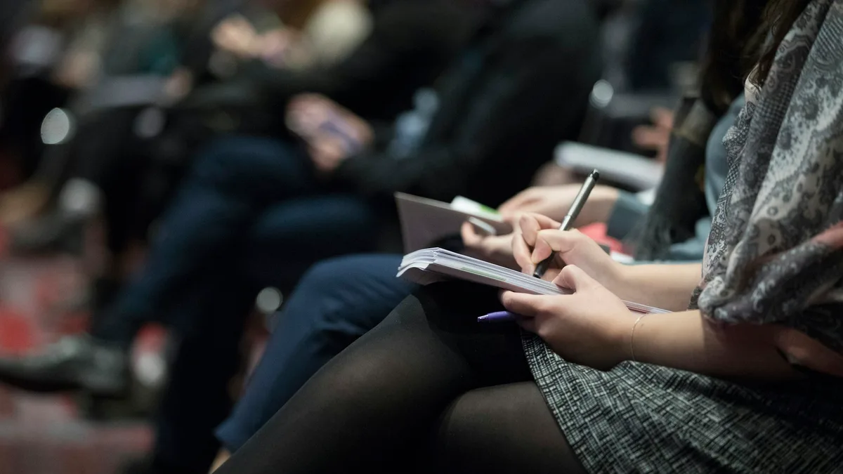 Team members writing notes together during a planning meeting