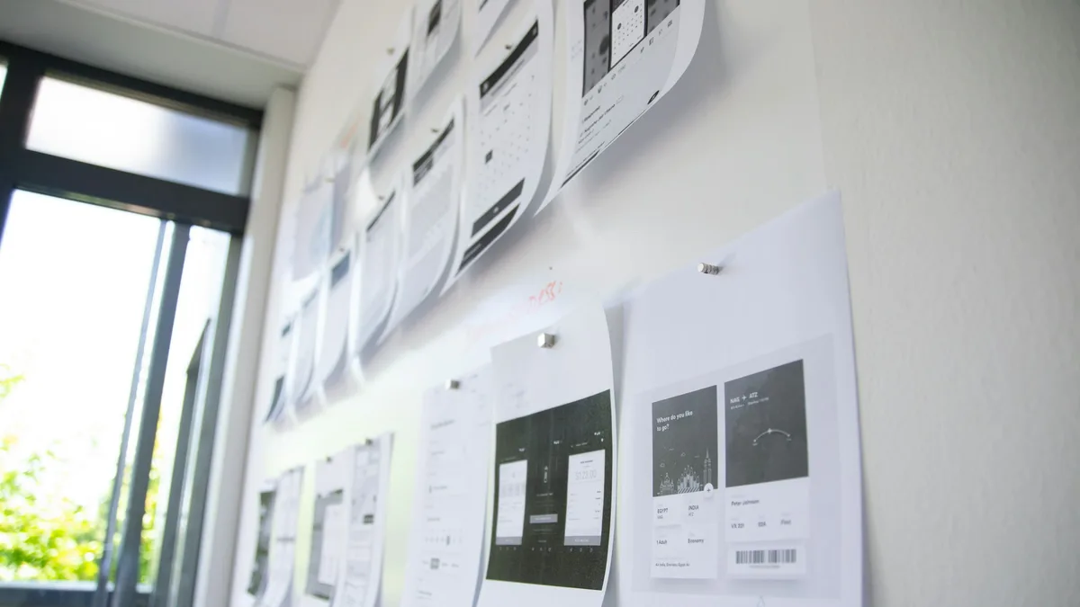 Sketches and sticky notes pinned to a wall during a planning session