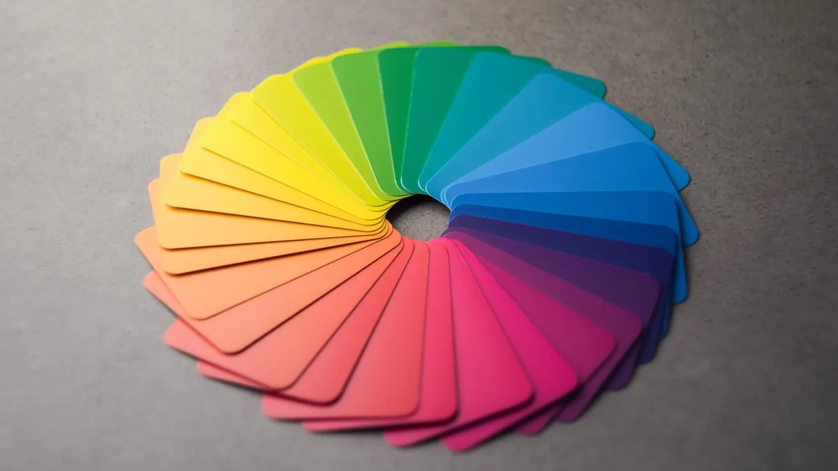 Rainbow color swatch cards fanned into a color wheel