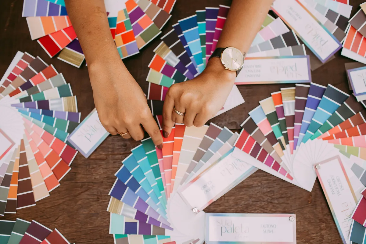 A person holding a printed sheet of solid color blocks up to the light