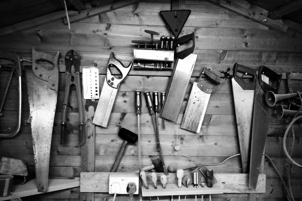 Assorted hand tools arranged in deliberate order, shot in grayscale