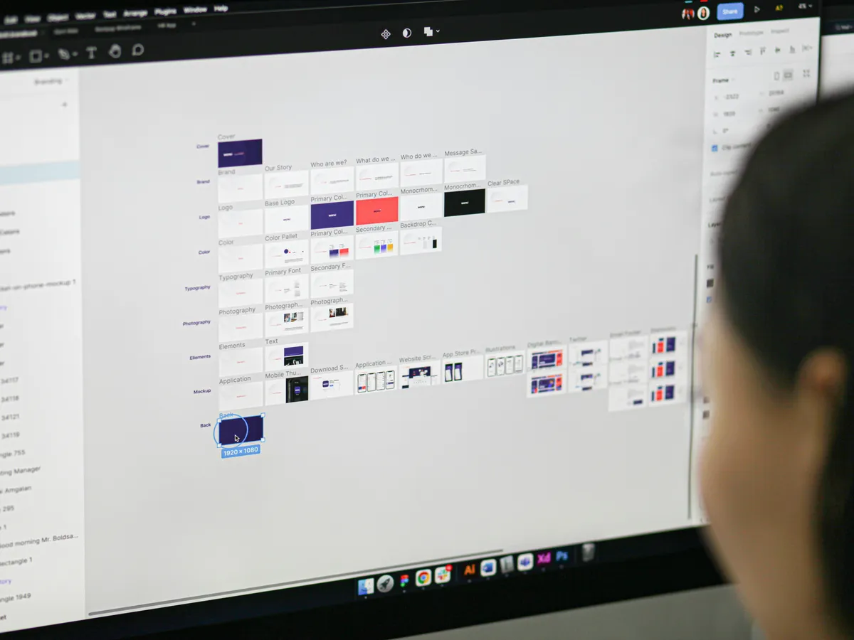 Designer working on a Figma design file on a computer screen