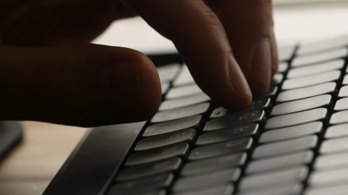 Close-up of a hand typing on a computer keyboard