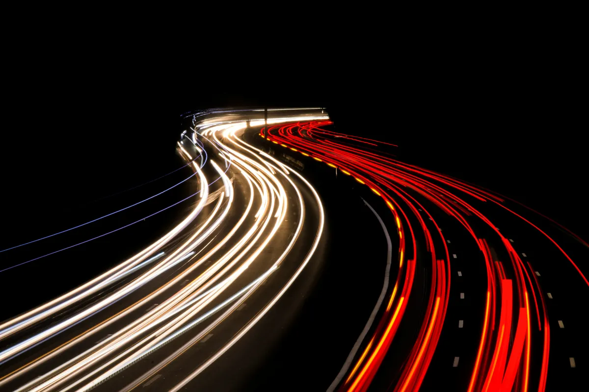 Long-exposure light trails curving through darkness, evoking a scrubbing animation timeline