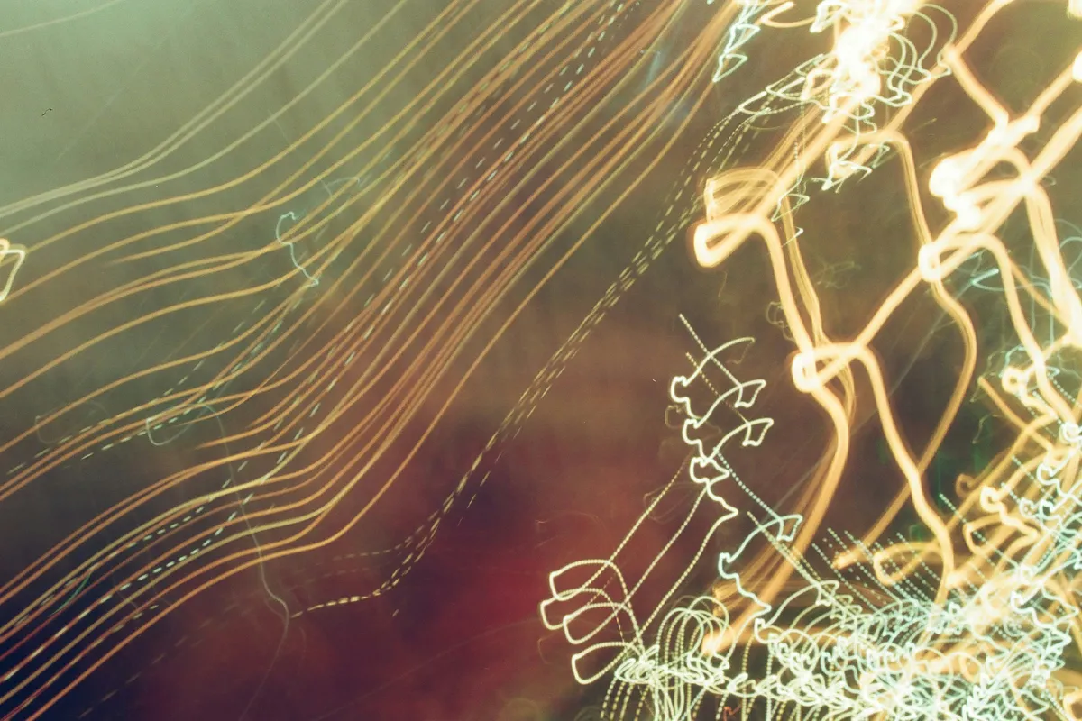 Warm light trails looping over a dark ground