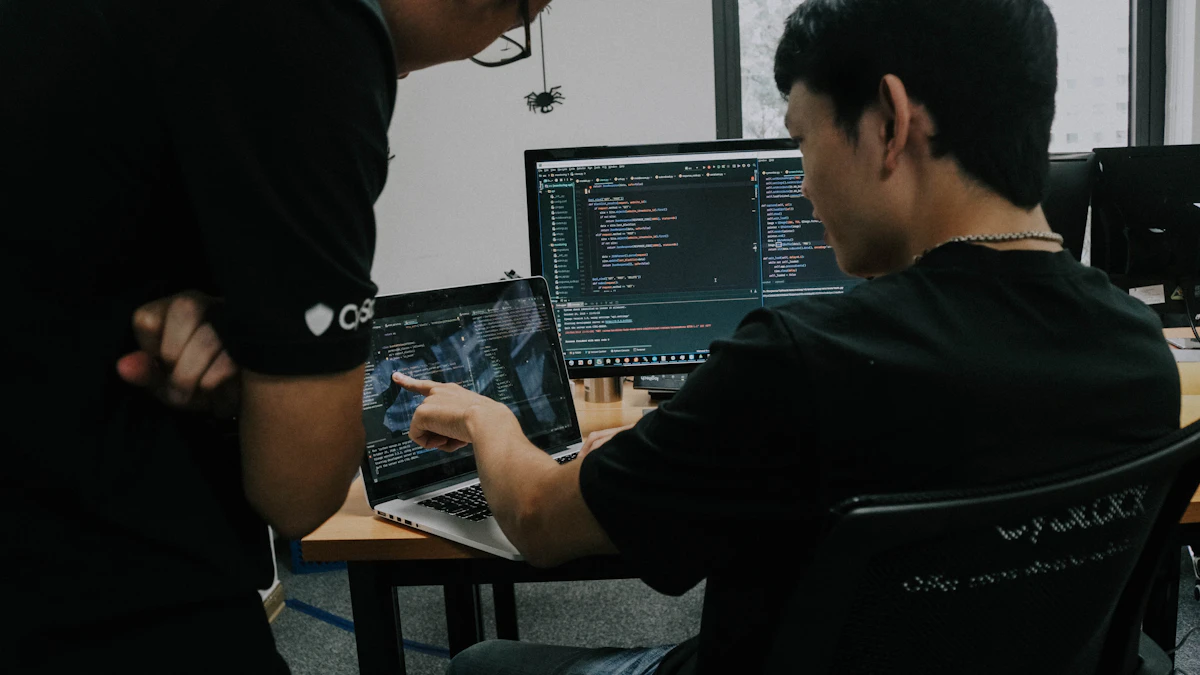 Two developers working side by side on computers in an office