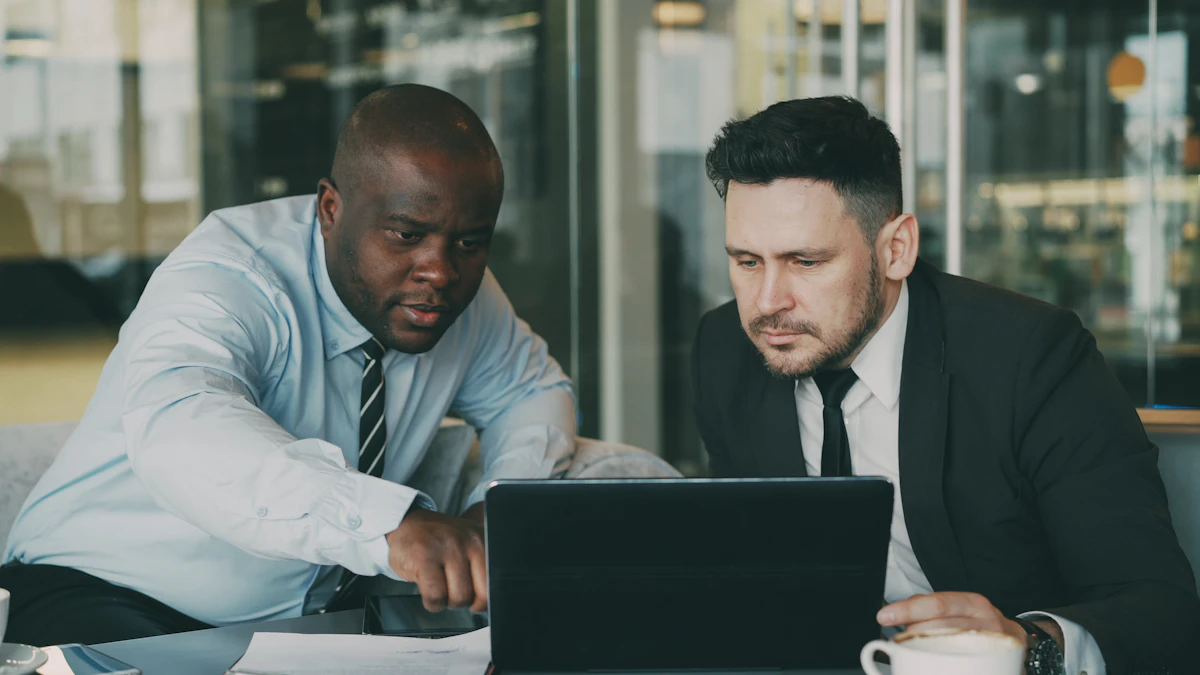 Two colleagues reviewing work together on a laptop in an office