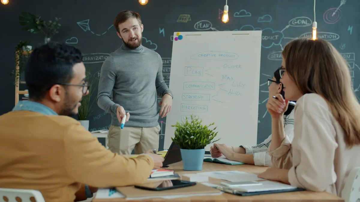 Team collaborating around a whiteboard during a project feedback session