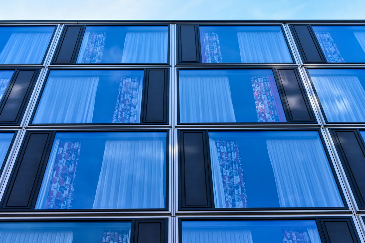 A blue glass facade where every panel matches the one beside it