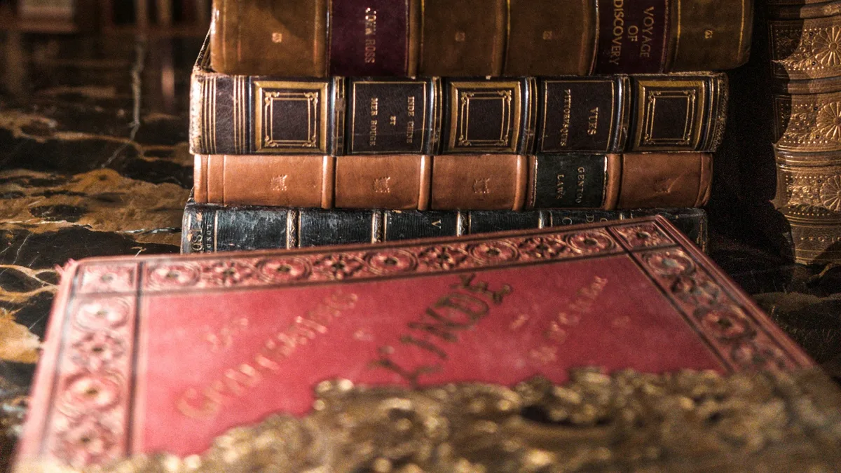 Stack of books on a wooden shelf in a library