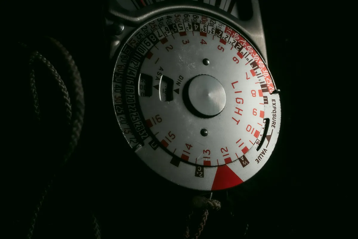 A speedometer dial lit up in the dark, needle rising through the sweep