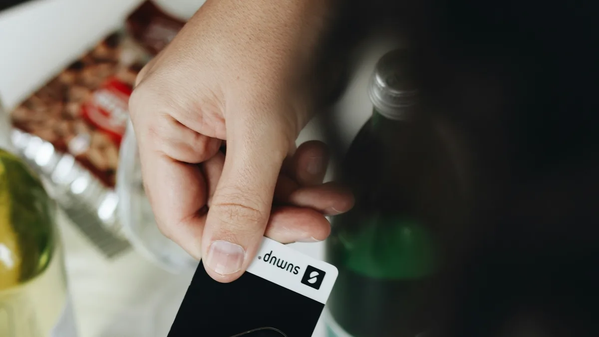 Hand using a smartphone for a contactless mobile payment, showing thumb-reach interaction