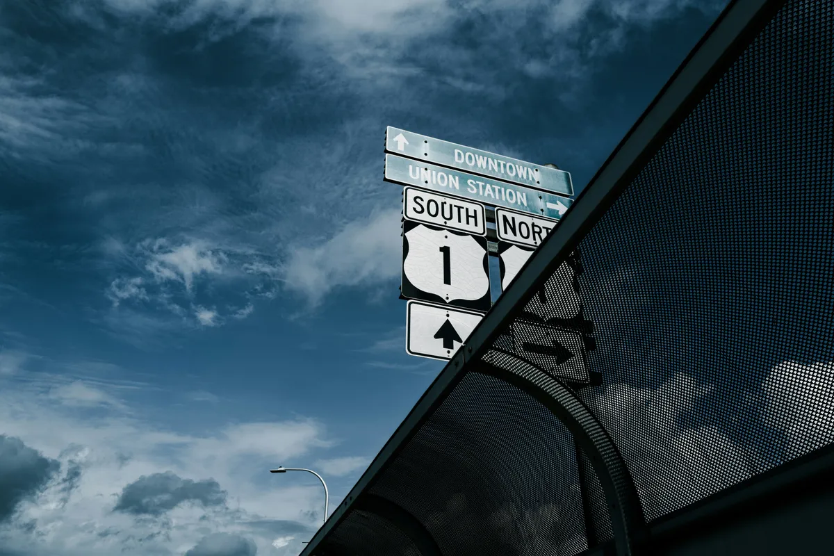 Road signs pointing toward downtown and route one from the same post