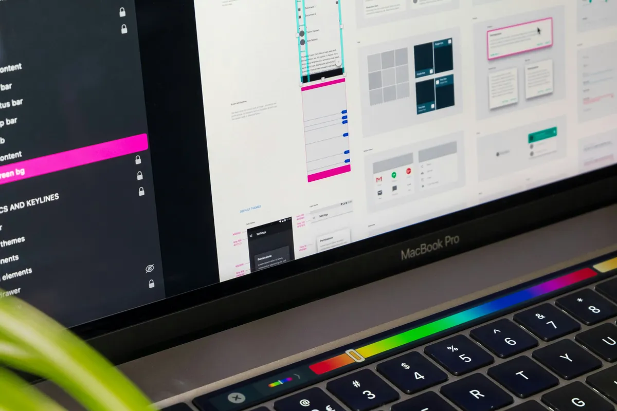 Design tool on a laptop showing a spec panel with redlines, spacing, and component layers