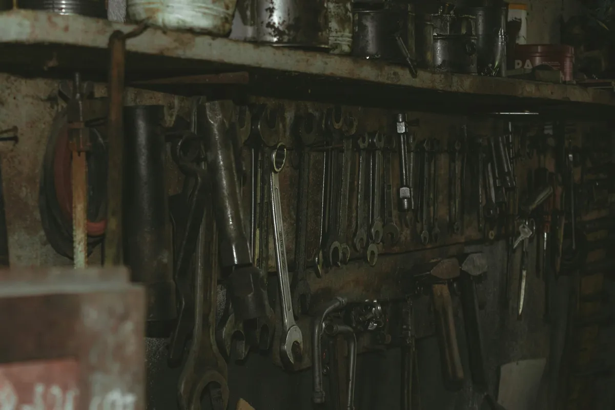 A single black metal tool resting alone on a wooden shelf