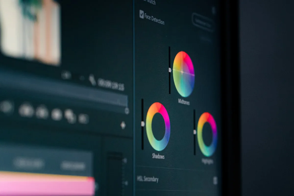 Designer workstation showing a video editing timeline and design software on screen