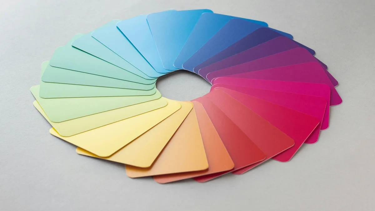 A circle of different paint color swatches arranged on a white surface