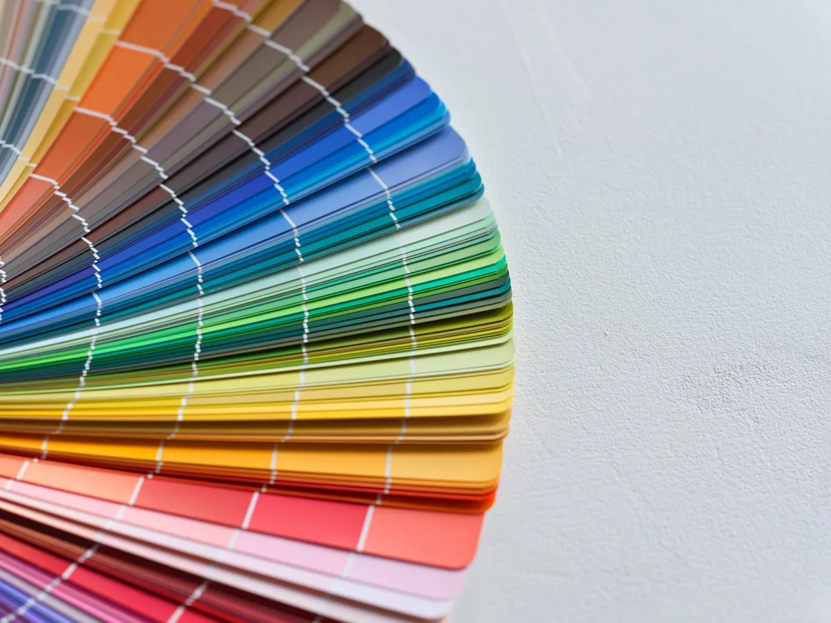 Fan of paint swatch cards spanning the full color spectrum