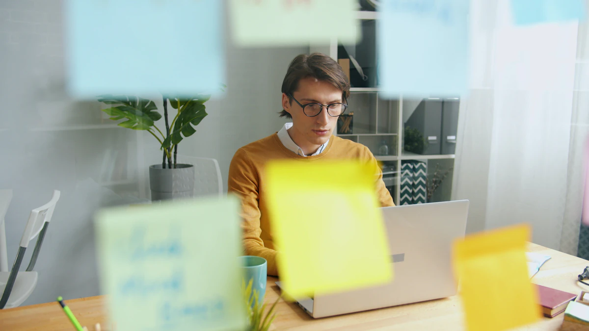 Person working on a laptop surrounded by colorful sticky notes