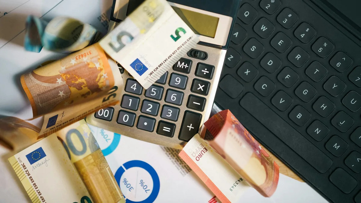 Calculator sitting on top of a pile of paper money