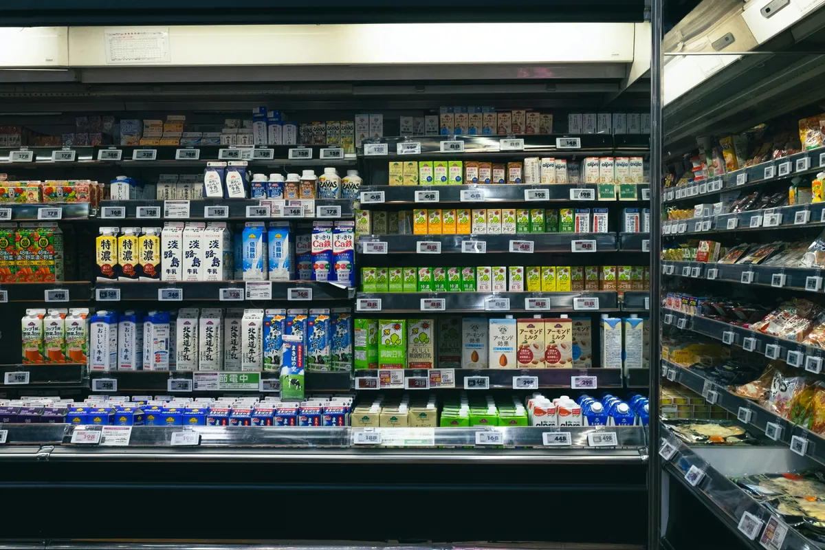 A wall of stocked shelves running the length of a store
