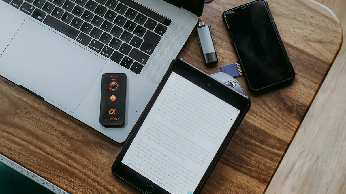Laptop, tablet, and phone on a wooden desk representing different screen widths a component must adapt to