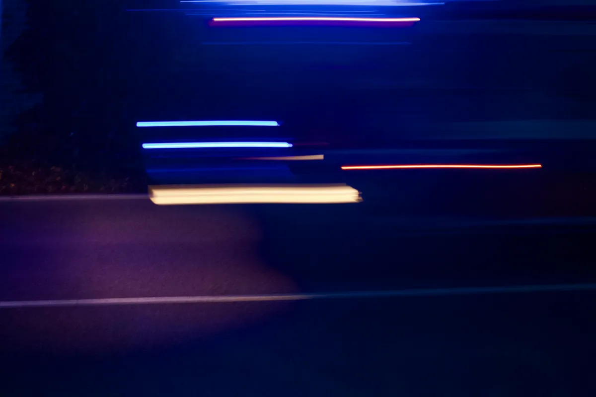 Violet light trails crossing a night frame