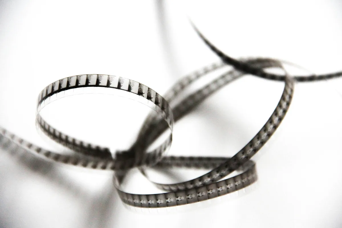 An old 8mm film strip on white, every individual frame visible