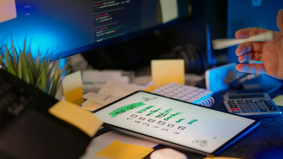 Developer working across multiple screens in a dimly lit dark office